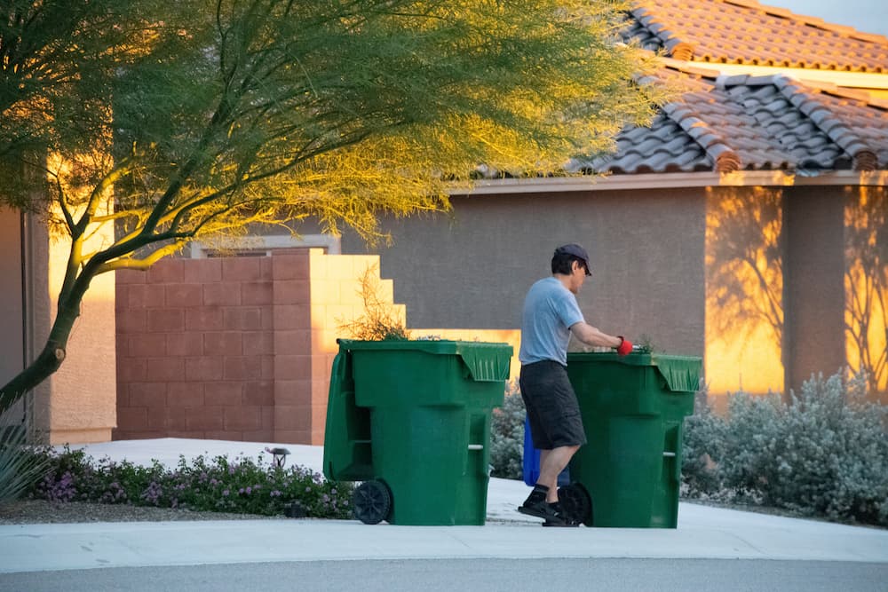 man-disposing-of-yard-waste-in-suburban-neighborho-2026-03-13-05-58-21-utc