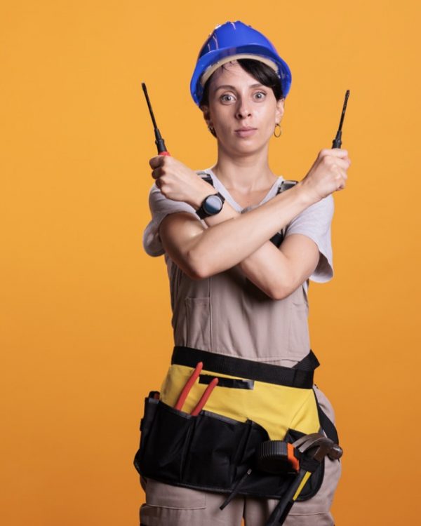 Woman construction worker holding screwdrivers