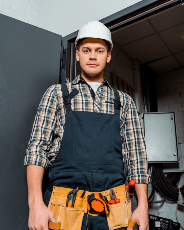 handsome installer in safety helmet looking at camera
