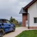 Close-up of electric car charging near family house.