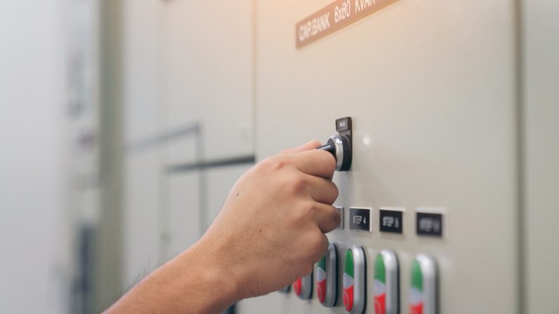Electrical engineer man checking voltage and test at the Power Distribution Cabinet in the control room, preventive maintenance Yearly